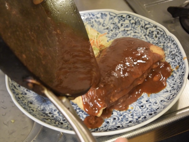 お揚げハンバーグにソースをかける